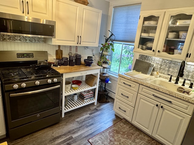 21 Wilson St, Eastport, ME 04631 - kitchen with range with gas stovetop, stainless steel microwave, light countertops, white cabinets, and dark wood finished floors