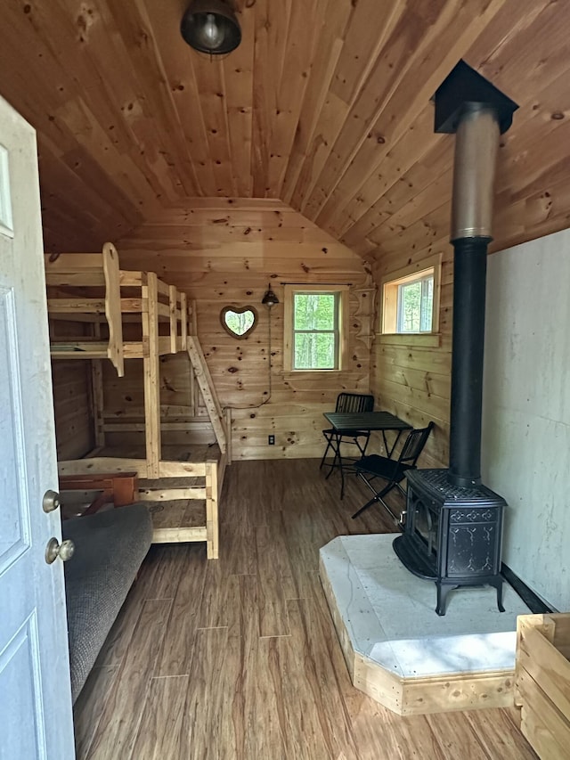 322 Lamb Rd, Roxbury, ME 04275 - unfurnished bedroom with vaulted ceiling, a wood stove, wood walls, wood finished floors, and wood ceiling