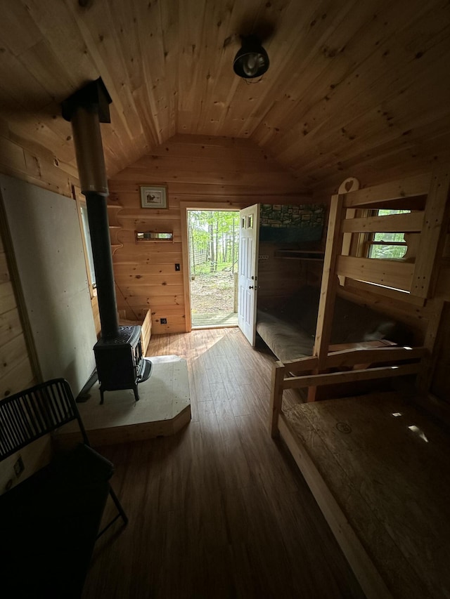 322 Lamb Rd, Roxbury, ME 04275 - living area featuring lofted ceiling, a wood stove, wooden ceiling, wood-type flooring, and wood walls