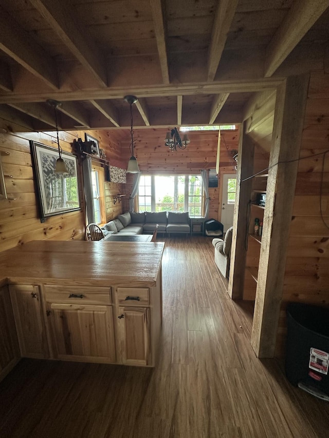 322 Lamb Rd, Roxbury, ME 04275 - kitchen featuring wood walls, dark wood-type flooring, beamed ceiling, hanging light fixtures, and a peninsula