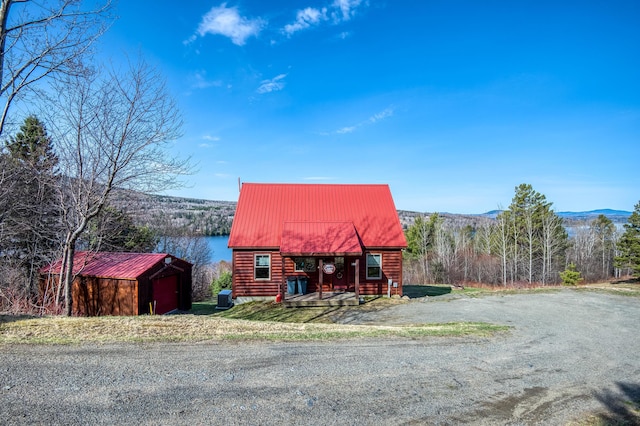 49 Winston Rd, Rangeley, ME 04970 - view of front of house with an outbuilding, a mountain view, and a metal roof