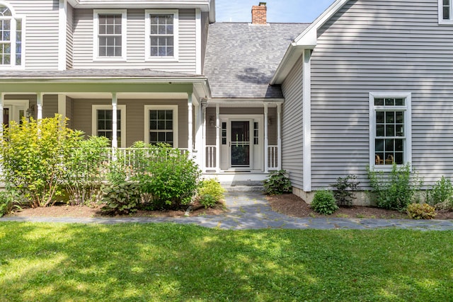 34 Perk Orock Landing Rd, Orono, ME 04473 - entrance to property featuring a lawn, covered porch, a chimney, and roof with shingles