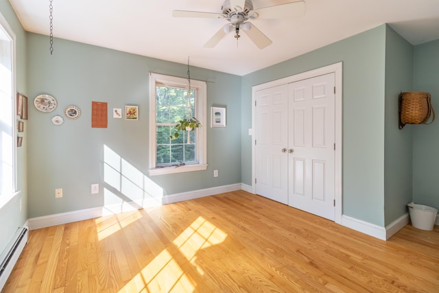 34 Perk Orock Landing Rd, Orono, ME 04473 - unfurnished bedroom featuring a baseboard heating unit, light wood finished floors, a closet, and a ceiling fan