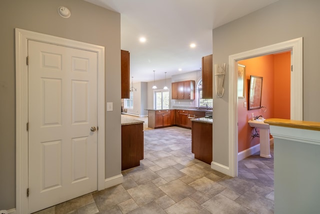 34 Perk Orock Landing Rd, Orono, ME 04473 - kitchen with brown cabinets, stone finish floors, decorative light fixtures, recessed lighting, and light stone counters