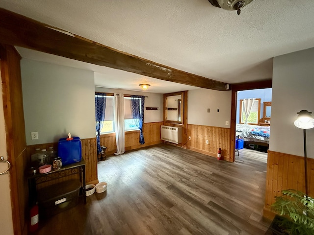 1897 Pequawket Trl, Hiram, ME 04041 - unfurnished living room with a wainscoted wall, wood walls, wood finished floors, a textured ceiling, and beam ceiling