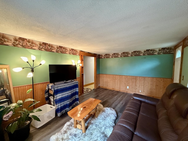 1897 Pequawket Trl, Hiram, ME 04041 - living area featuring wainscoting, wooden walls, a textured ceiling, and wood finished floors