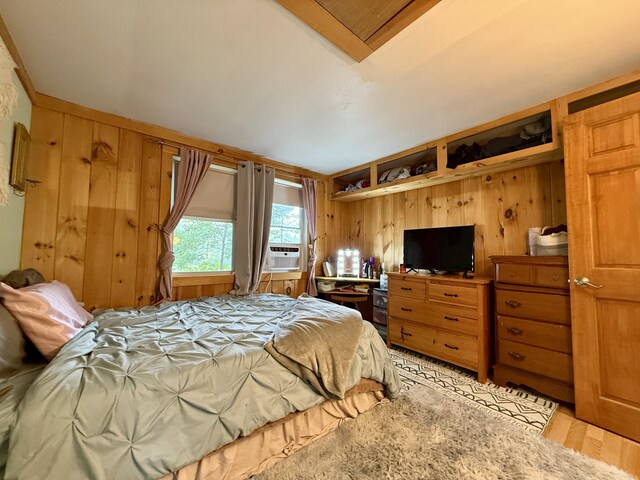 1897 Pequawket Trl, Hiram, ME 04041 - bedroom with wood walls, light wood-style floors, and cooling unit