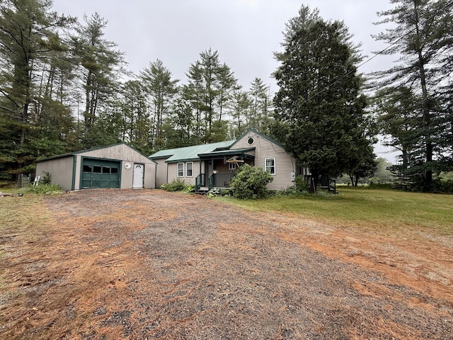 1897 Pequawket Trl, Hiram, ME 04041 - view of side of property featuring a garage, dirt driveway, an outbuilding, and a porch