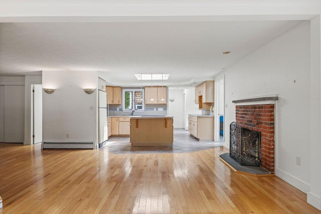 13 Community House Rd, Kennebunkport, ME 04046 - kitchen with a baseboard heating unit, light wood finished floors, a center island, light countertops, and freestanding refrigerator