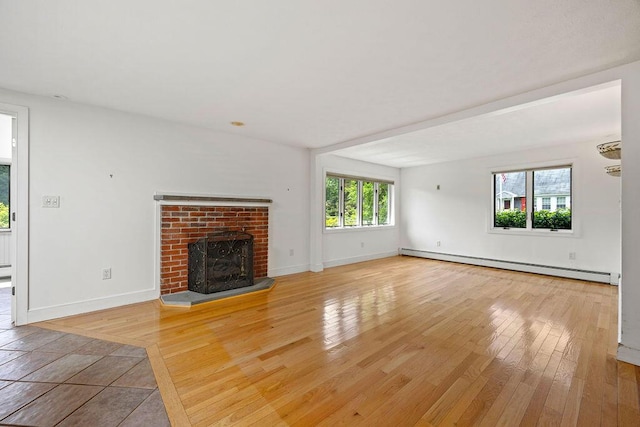 13 Community House Rd, Kennebunkport, ME 04046 - unfurnished living room with baseboard heating, a brick fireplace, and light wood-style flooring