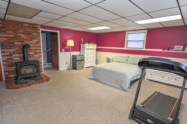 13 Evergreen Dr, Hampden, ME 04444 - carpeted bedroom featuring a paneled ceiling, a wainscoted wall, and a wood stove