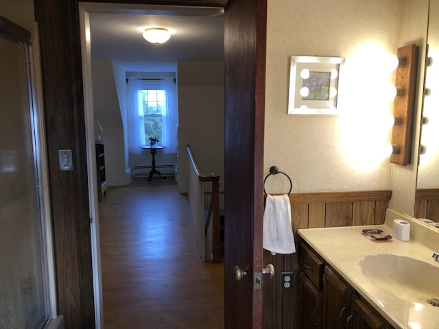 95 Main St, Lubec, ME 04652 - bathroom featuring a baseboard radiator, wood finished floors, vanity, and a shower with shower door