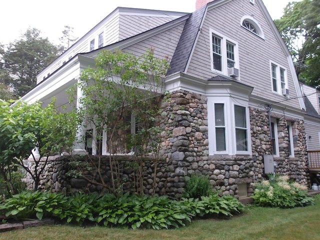 18 Wayman Ln, Bar Harbor, ME 04609 - view of side of home with stone siding and a gambrel roof