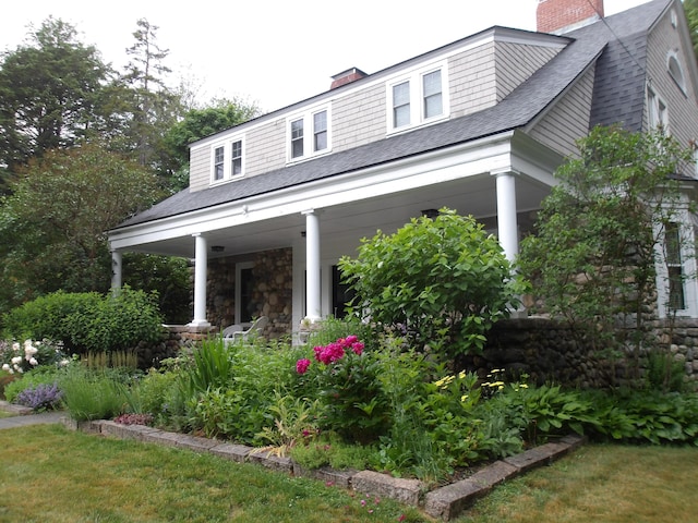 18 Wayman Ln, Bar Harbor, ME 04609 - view of front facade with a porch, a chimney, and a shingled roof