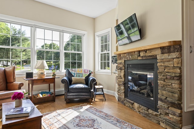 28 Evergreen Dr, Boothbay, ME 04537 - living room with wood finished floors, a fireplace, and a baseboard heating unit