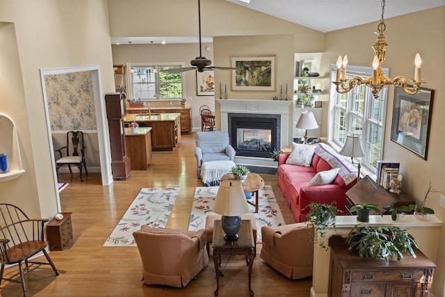 28 Evergreen Dr, Boothbay, ME 04537 - living area with light wood-style floors, a tiled fireplace, vaulted ceiling, a chandelier, and ceiling fan