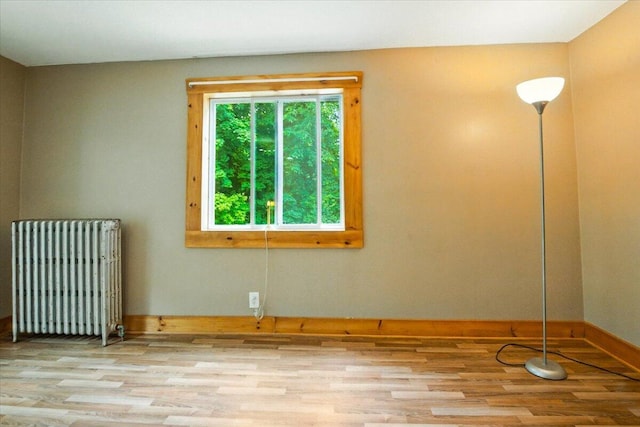 90 Newbury St, Auburn, ME 04210 - empty room with radiator heating unit and wood finished floors