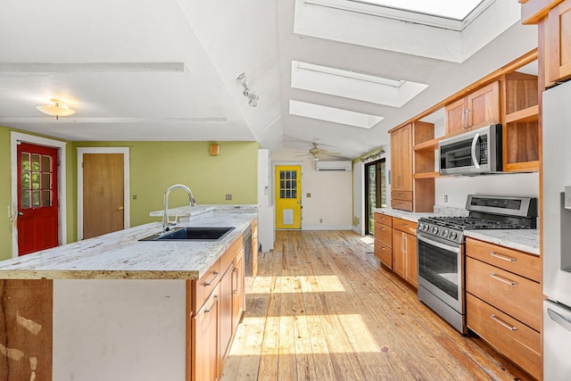 276 W St, Biddeford, ME 04005 - kitchen featuring stainless steel appliances, a skylight, open shelves, light wood-type flooring, and a wall mounted air conditioner