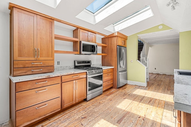 276 W St, Biddeford, ME 04005 - kitchen with stainless steel appliances, open shelves, a skylight, light wood-type flooring, and lofted ceiling