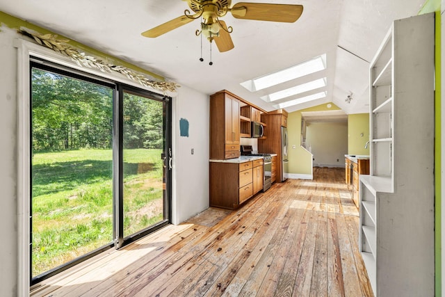 276 W St, Biddeford, ME 04005 - kitchen featuring open shelves, stainless steel appliances, a skylight, light wood-type flooring, and light countertops