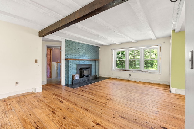 276 W St, Biddeford, ME 04005 - unfurnished living room with beamed ceiling, hardwood / wood-style flooring, and a wood stove