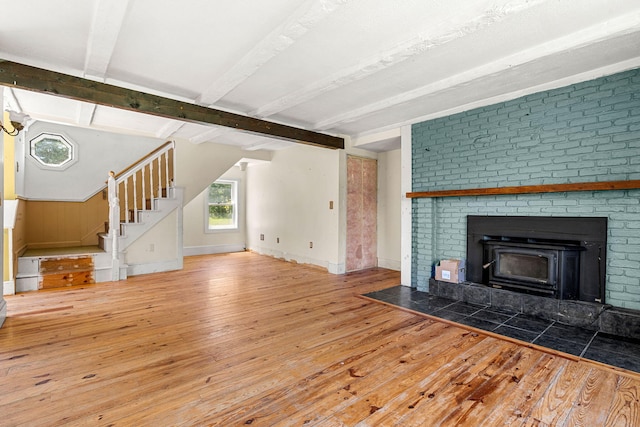 276 W St, Biddeford, ME 04005 - unfurnished living room featuring wood-type flooring, beam ceiling, and stairs