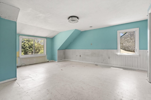 276 W St, Biddeford, ME 04005 - additional living space featuring lofted ceiling, a wainscoted wall, and unfinished concrete flooring