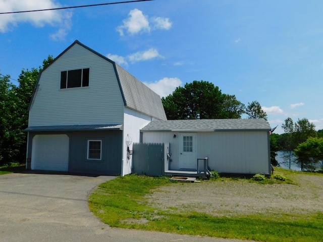208 Fern Rd, Dexter, ME 04930 - dutch colonial featuring a gambrel roof, a shingled roof, driveway, and an attached garage