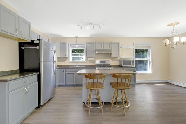 102 Mountain View Rd, Leeds, ME 04263 - kitchen with stainless steel appliances, under cabinet range hood, gray cabinetry, a center island, and light wood finished floors