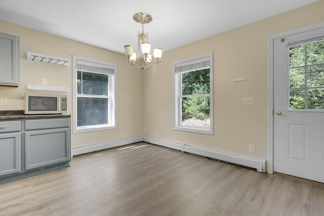 102 Mountain View Rd, Leeds, ME 04263 - unfurnished dining area with a chandelier, light wood-style floors, and baseboard heating