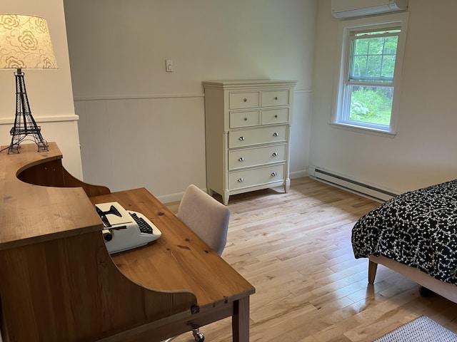 363 Oak Point Rd, Trenton, ME 04605 - bedroom featuring baseboard heating, an AC wall unit, light wood-type flooring, and wainscoting