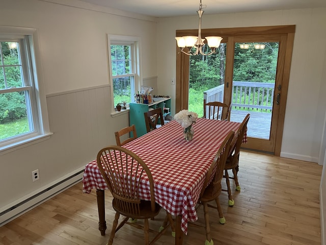 363 Oak Point Rd, Trenton, ME 04605 - dining space with baseboard heating, a chandelier, light wood finished floors, healthy amount of natural light, and wainscoting