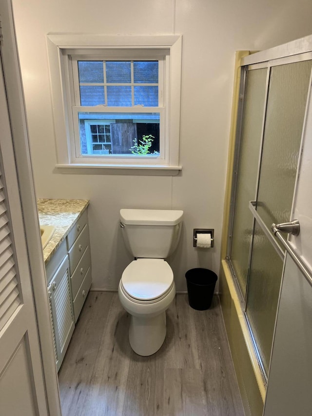 363 Oak Point Rd, Trenton, ME 04605 - bathroom with wood finished floors, vanity, and bath / shower combo with glass door