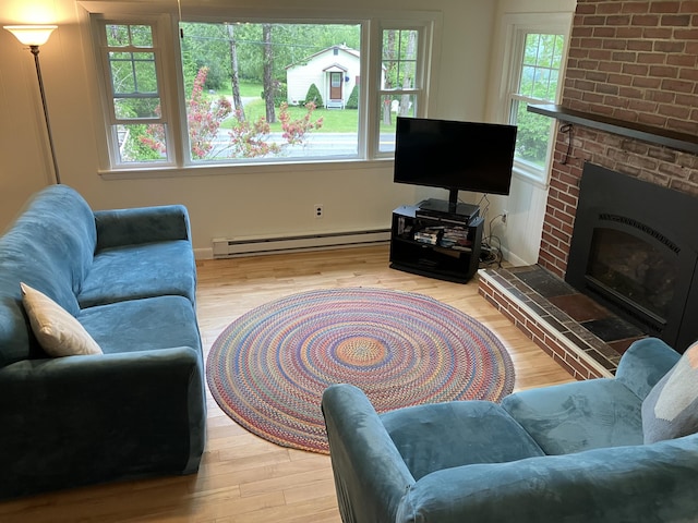 363 Oak Point Rd, Trenton, ME 04605 - living area with a baseboard radiator, wood finished floors, and a fireplace