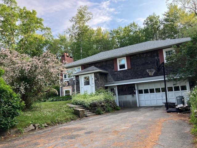 363 Oak Point Rd, Trenton, ME 04605 - bi-level home with a garage, asphalt driveway, a chimney, and roof with shingles