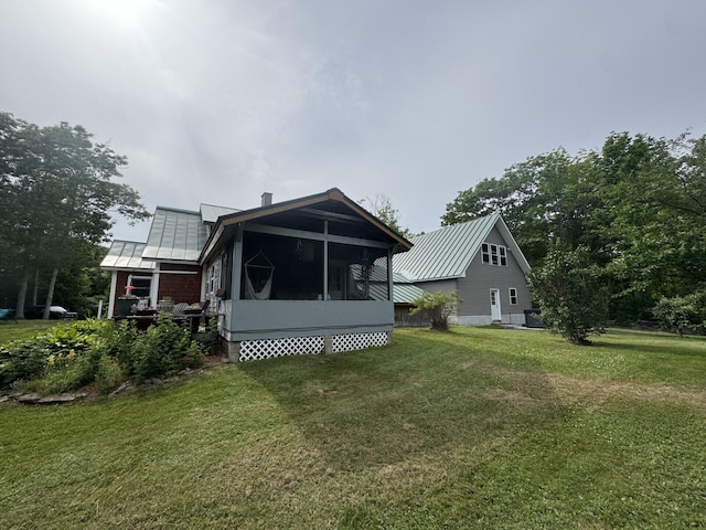 71 Garland Rd, Dixmont, ME 04932 - rear view of property featuring a sunroom, a metal roof, and a lawn