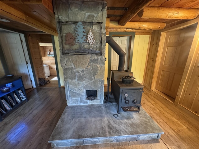 71 Garland Rd, Dixmont, ME 04932 - detailed view of a wood stove, wood finished floors, a wood ceiling with exposed beams, and wooden walls