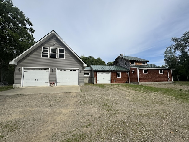 71 Garland Rd, Dixmont, ME 04932 - view of front facade featuring dirt driveway, a standing seam roof, a metal roof, and a garage