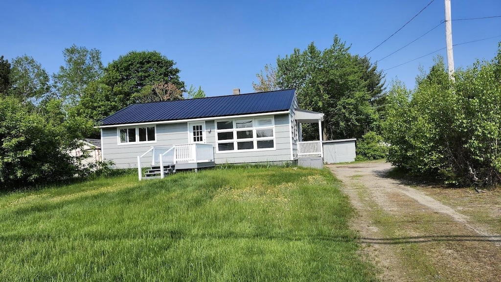 309 Bates St, Millinocket, ME 04462 - view of front facade featuring dirt driveway and a metal roof