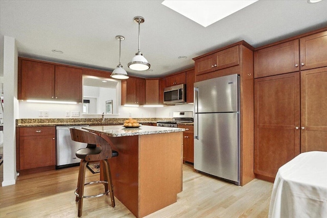 17 Beryl Loop Unit F65, Topsham, ME 04086 - kitchen featuring appliances with stainless steel finishes, light wood-type flooring, a kitchen island, pendant lighting, and recessed lighting