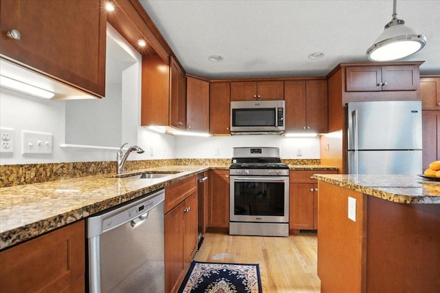 17 Beryl Loop Unit F65, Topsham, ME 04086 - kitchen with appliances with stainless steel finishes, light wood-type flooring, light stone counters, brown cabinets, and recessed lighting