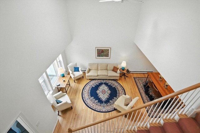 17 Beryl Loop Unit F65, Topsham, ME 04086 - living room featuring a towering ceiling, stairs, wood finished floors, and ceiling fan