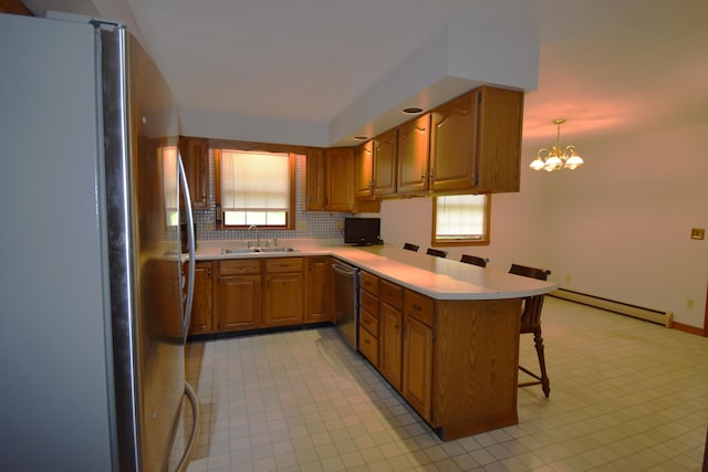 94 Blaisdell Rd, Newport, ME 04953 - kitchen with freestanding refrigerator, a baseboard radiator, stainless steel dishwasher, a peninsula, and a breakfast bar