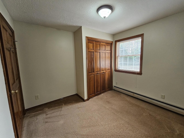 94 Blaisdell Rd, Newport, ME 04953 - unfurnished bedroom featuring a baseboard radiator, light carpet, a closet, and a textured ceiling