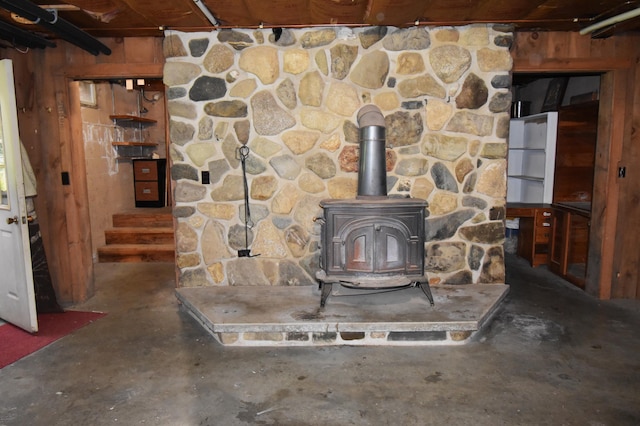 94 Blaisdell Rd, Newport, ME 04953 - detailed view of concrete flooring, a wood stove, and wood walls