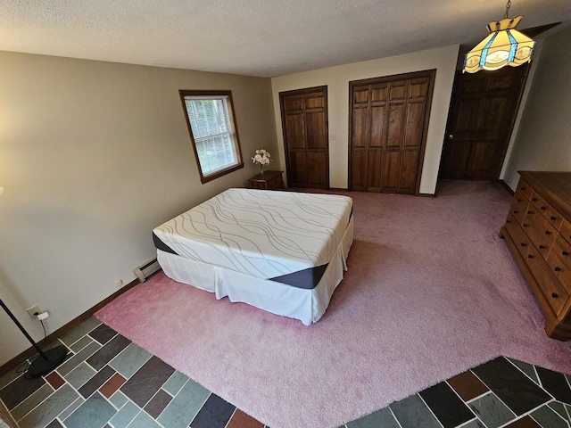 94 Blaisdell Rd, Newport, ME 04953 - bedroom with two closets, carpet floors, baseboard heating, and a textured ceiling