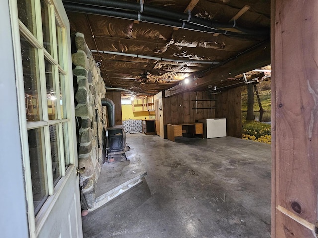 94 Blaisdell Rd, Newport, ME 04953 - unfinished basement featuring a wood stove and fridge