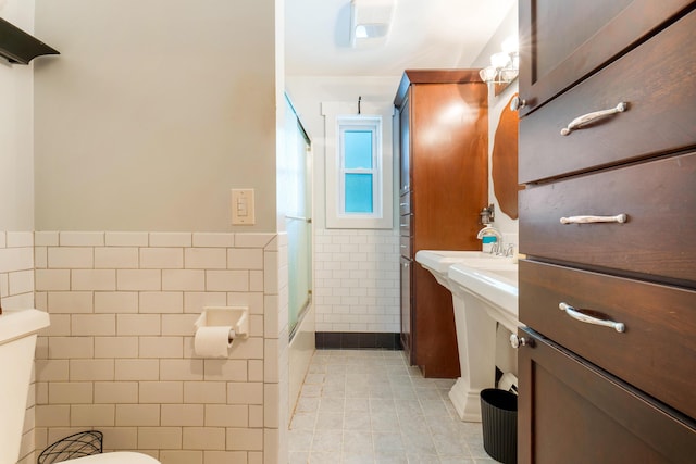 736 Webster St, Lewiston, ME 04240 - bathroom with tile walls, tile patterned flooring, washtub / shower combination, and wainscoting