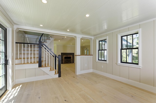 239 Ocean Point Rd, Boothbay, ME 04544 - unfurnished living room featuring stairs, wood-type flooring, ornamental molding, a fireplace, and recessed lighting
