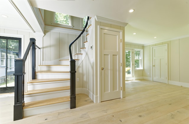 239 Ocean Point Rd, Boothbay, ME 04544 - stairway featuring crown molding, wood finished floors, recessed lighting, and a decorative wall